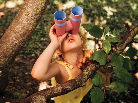 A child looks through binoculars