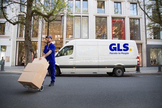 A delivery man carries packages on a dolly