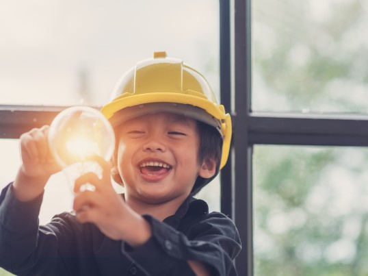 A child holds a bright lightbulb 