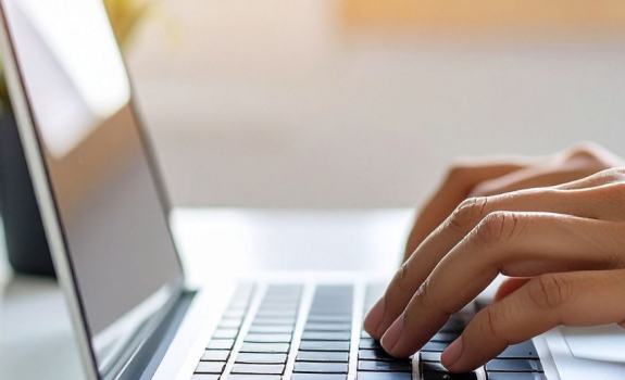 Hands typing on a laptop 